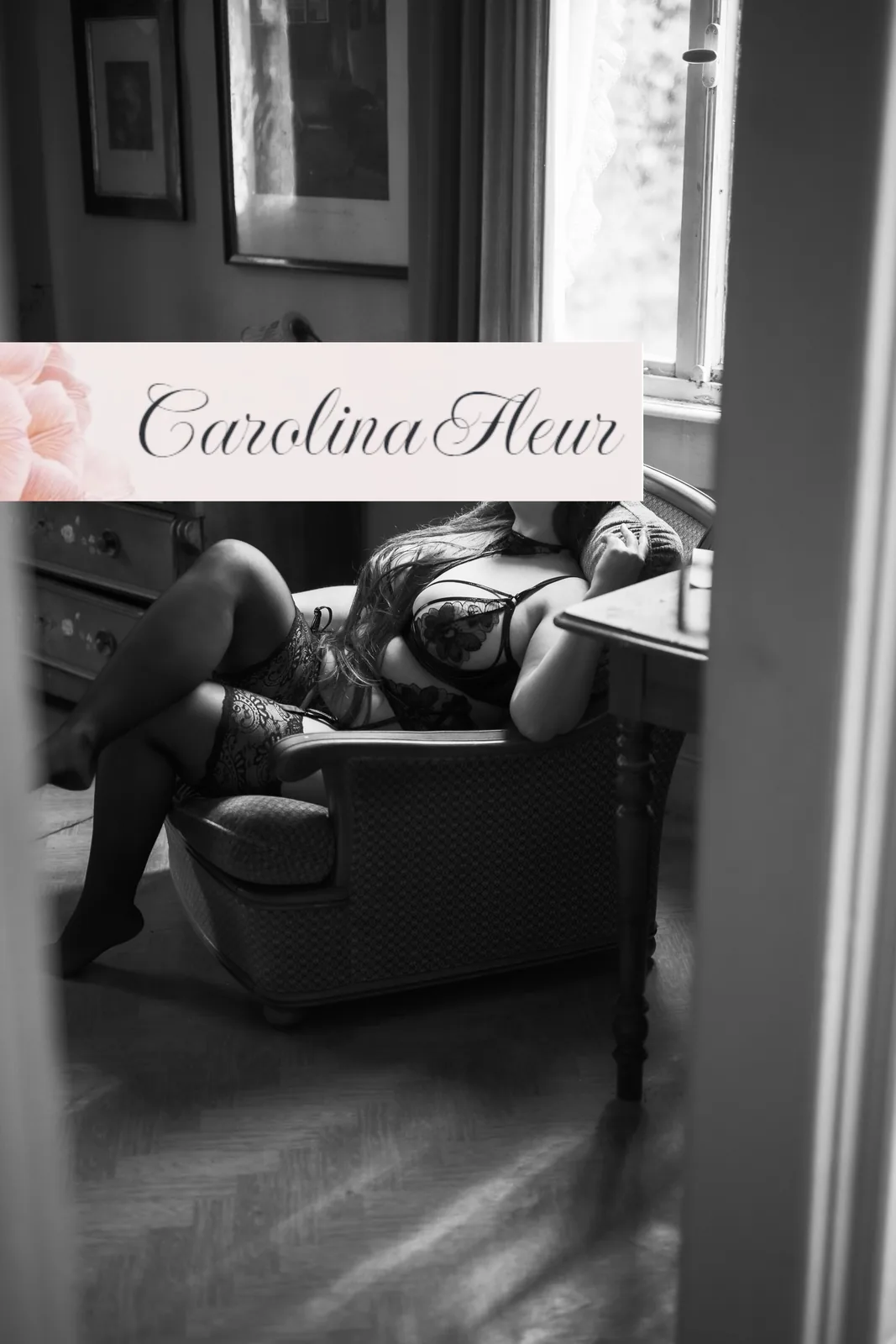 Carolina Fleur entspannt in einem Ledersessel am Fenster, Blick durch eine Tür