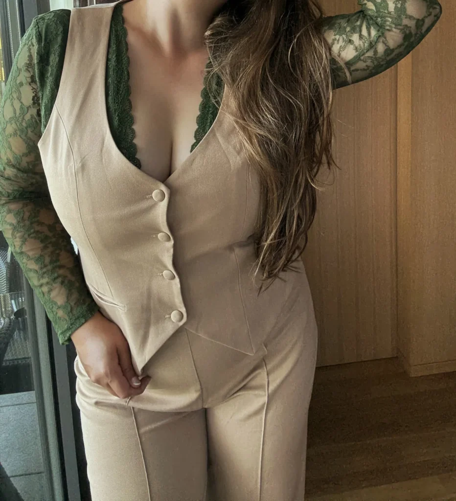 Carolina Fleur, Curvy Escort aus München, im Business-Outfit mit Knopfweste und Spitze