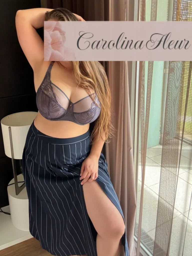 Carolina Fleur in blauen BH und Nadelstreifenrock Fenster