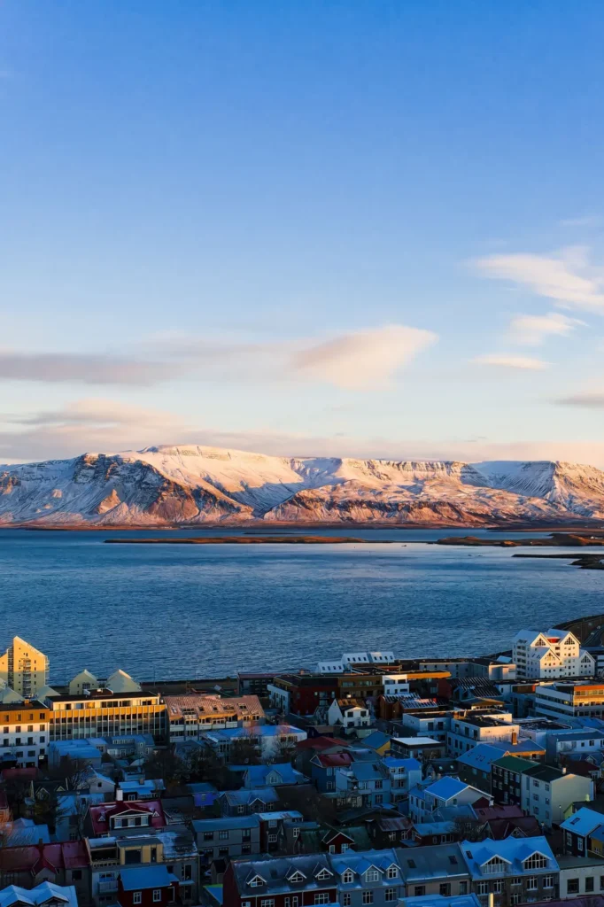 Blick über Reykjavík und die Bucht auf den schneebedeckten Berg Esja im Morgenlicht